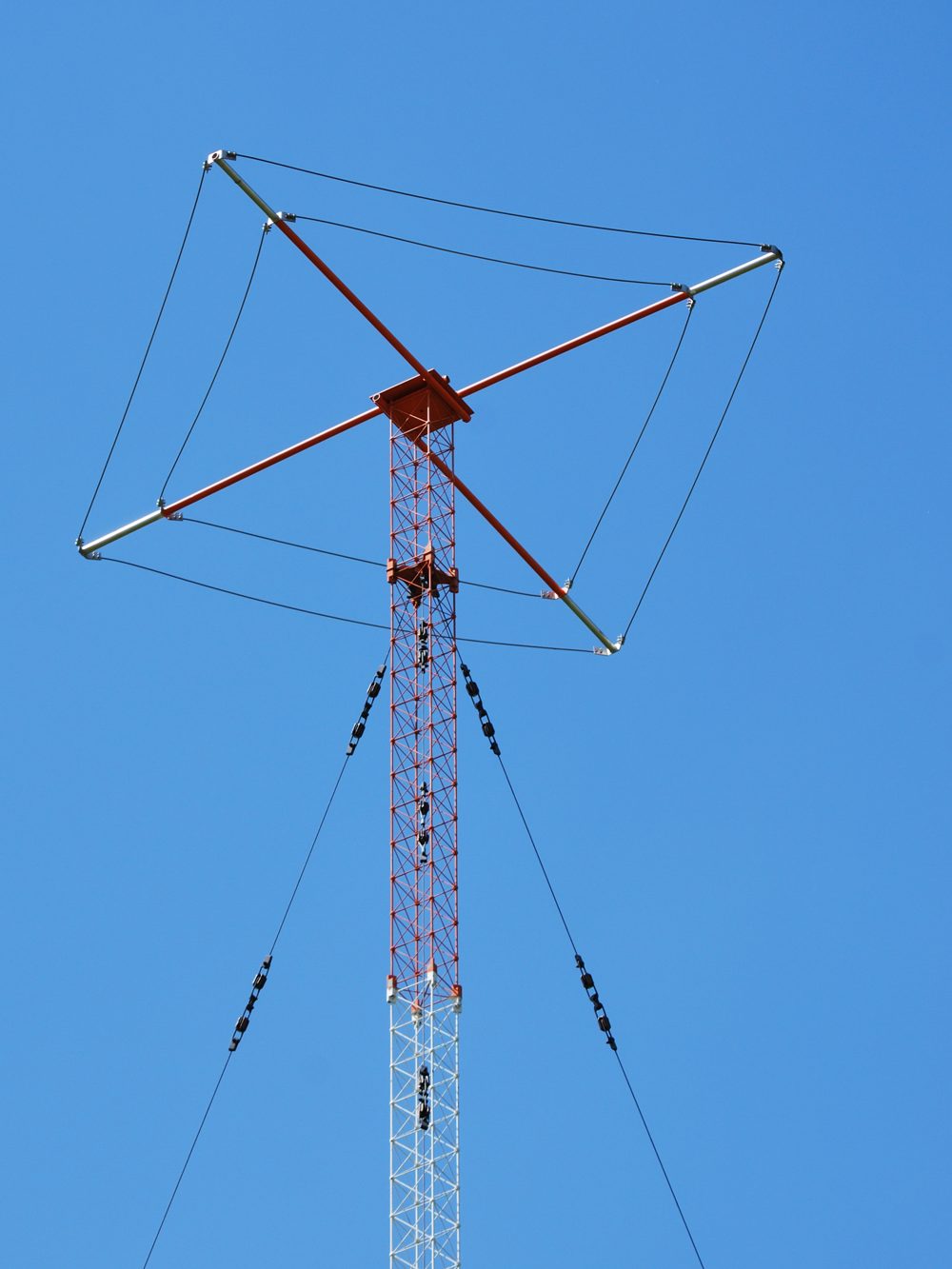 Figure 1 — A capacitive top-loading "hat" (Dachkapazität) on an AM broadcast mast radiator — the wire umbrella that raises the current at the physical top of a shortened radiator, the same principle this volu…