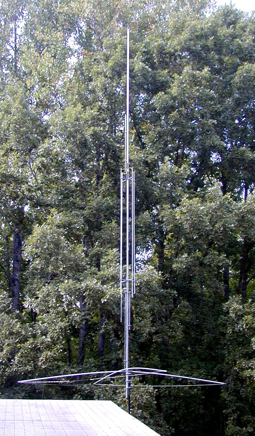 Figure 1 — The GAP Titan DX in the field — a premium no-radials commercial vertical, its four rigid elevated counterpoises visible sloping down from the center-fed base. Photo: GAP Antenna Products product ga…