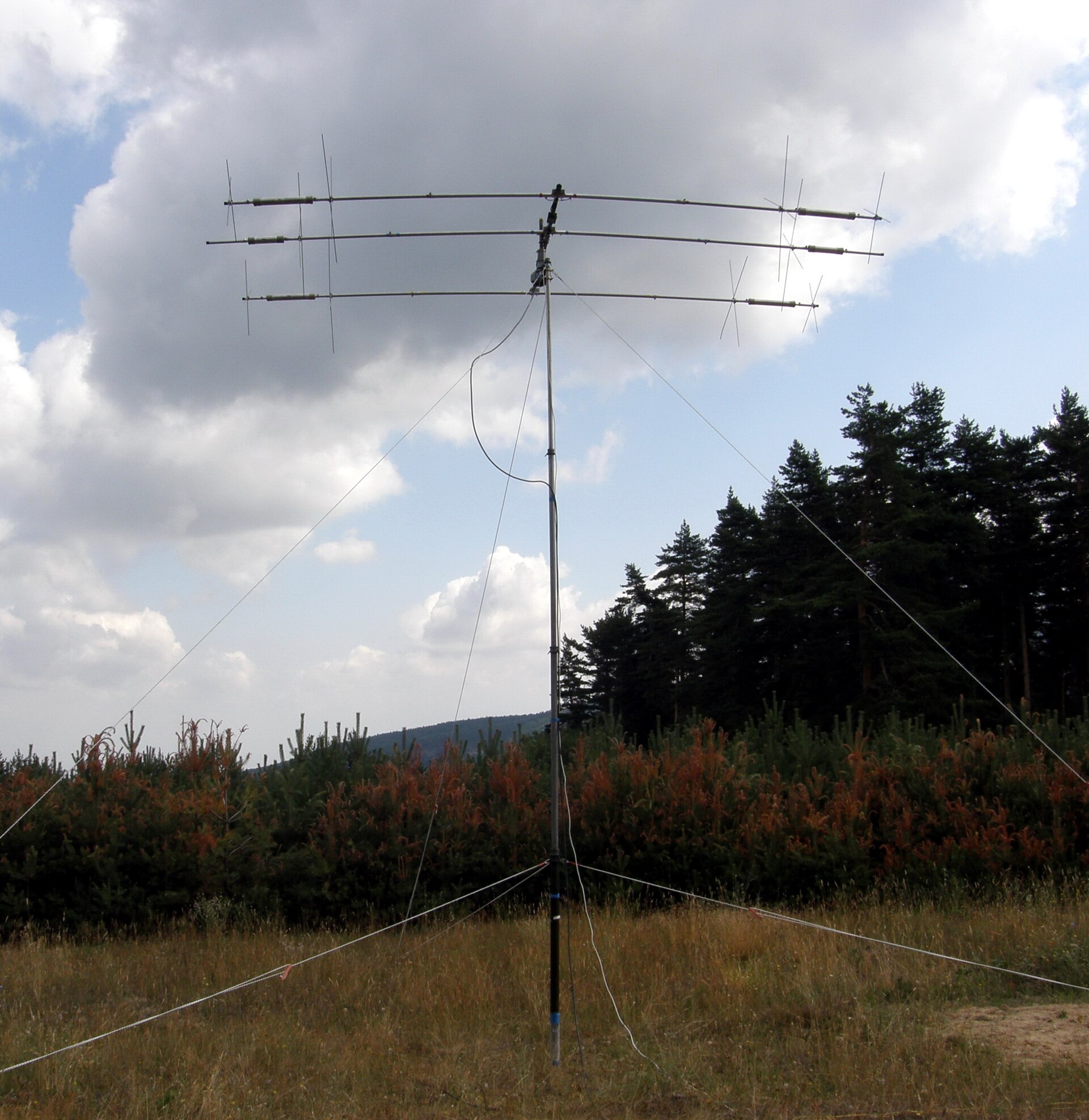 Figure 1 — A 3-element Yagi against open sky — the driven element is the center rod on the boom, flanked by the reflector (rear) and director (forward). This volume owns everything that happens at that one in…