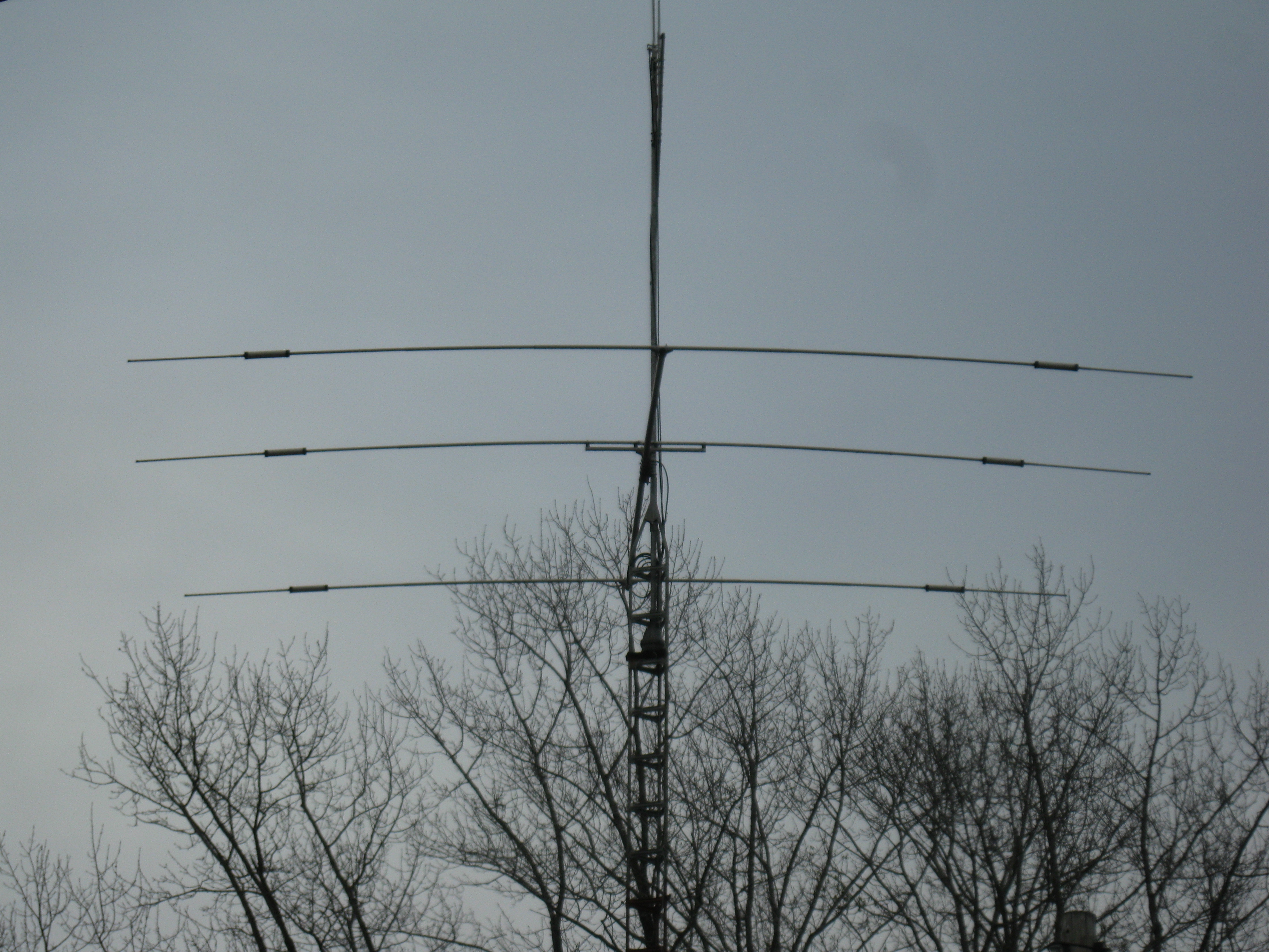 Figure 5 — A Mosley TA-33 — a three-element trapped HF tribander — at the top of its tower. The three horizontal elements are this one antenna's reflector, driven element and director seen close to boresight,…